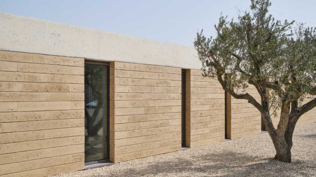 Interior wall constructed with Fetdeterra unbaked compressed earth blocks, demonstrating structural thermal mass and natural clay textures without synthetic finishes.
