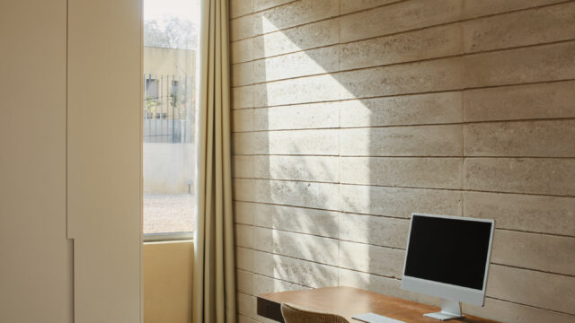 Interior wall constructed with Fetdeterra unbaked compressed earth blocks, demonstrating structural thermal mass and natural clay textures without synthetic finishes.