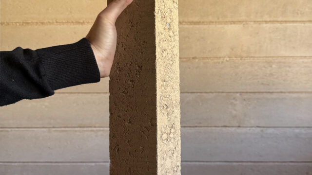 Interior wall constructed with Fetdeterra unbaked compressed earth blocks, demonstrating structural thermal mass and natural clay textures without synthetic finishes.