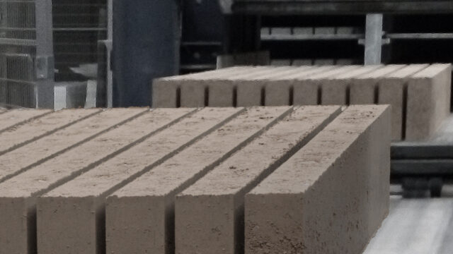 Interior wall constructed with Fetdeterra unbaked compressed earth blocks, demonstrating structural thermal mass and natural clay textures without synthetic finishes.