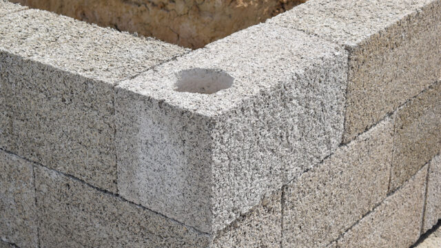 Timber frame construction utilizing IsoHemp hemp-lime masonry blocks for carbon-negative, vapor-permeable thermal insulation.