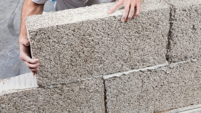 Timber frame construction utilizing IsoHemp hemp-lime masonry blocks for carbon-negative, vapor-permeable thermal insulation.