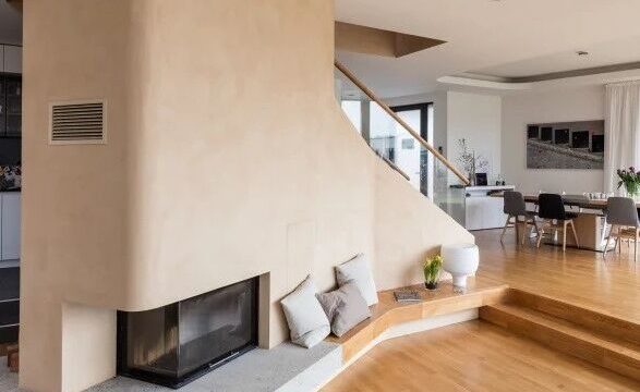 Interior wall installation using Claytec raw clay boards (Lehmbauplatten) and finished with natural clay plaster, replacing conventional gypsum drywall.