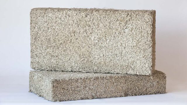Biomattone® pre-cast hempcrete blocks stacked on a construction site, ready for dry assembly as a biogenic infill wall.