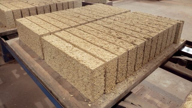 Biomattone® pre-cast hempcrete blocks stacked on a construction site, ready for dry assembly as a biogenic infill wall.
