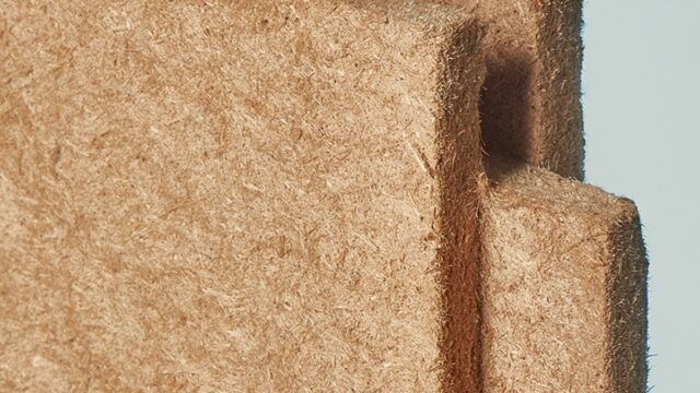 Claytec dry building boards installed on an interior stud frame, replacing traditional synthetic gypsum drywall with a raw earth bio-composite.