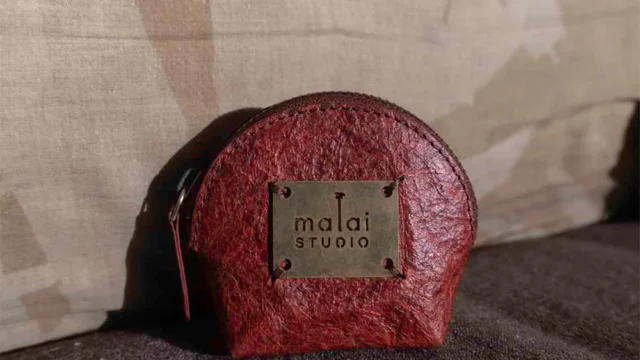 Flexible sheets of Malai bio-composite, created from coconut water-derived bacterial cellulose and natural fibers, showcasing an organic, leather-like texture.