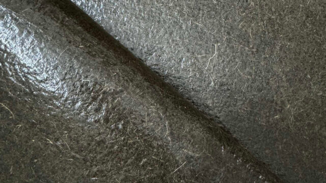 Flexible sheets of Malai bio-composite, created from coconut water-derived bacterial cellulose and natural fibers, showcasing an organic, leather-like texture.